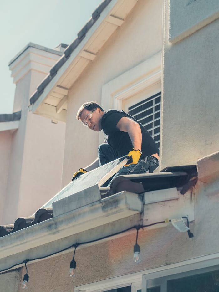why-choose-us A worker is installing solar panels on a residential rooftop, promoting clean energy.