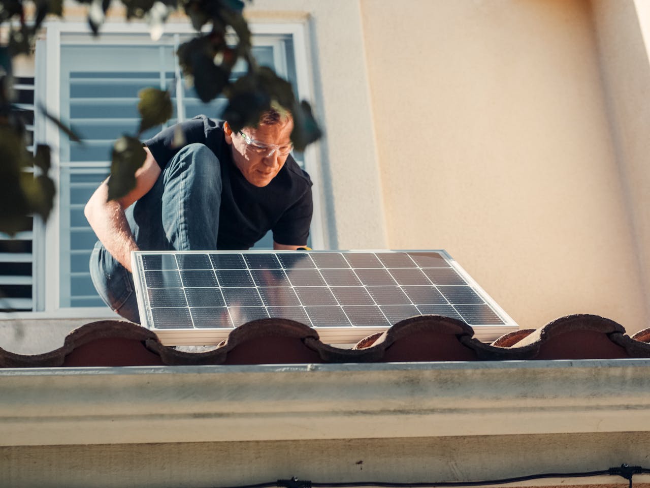 creative-02 A technician installs a solar panel on a house roof, embracing clean energy solutions.