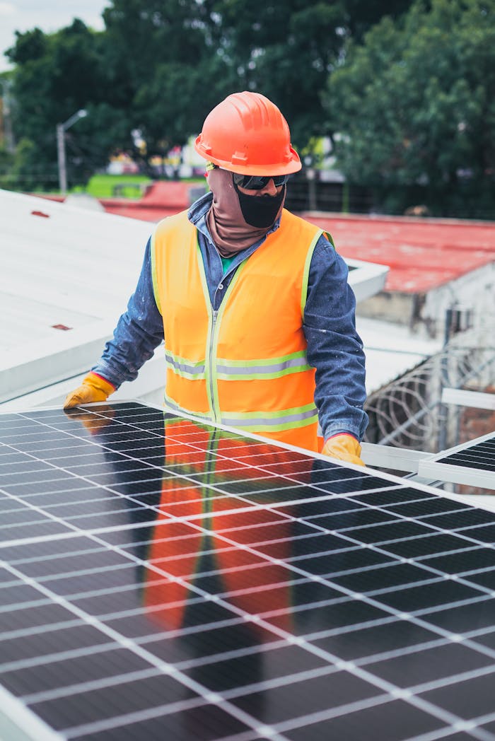 creative-02 Technician in protective gear installing solar panels on a sunny day.